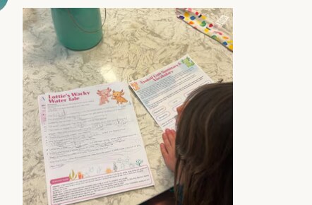 A young child at the kitchen table working through Kind Street Library's Lottie the Axolotl unit study printable pages